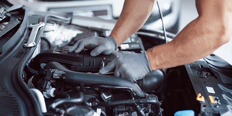 James Wood Motors Decatur in Decatur TX close up of technician with hands on an engine