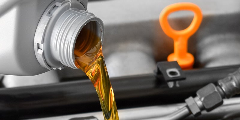 James Wood Motors Decatur in Decatur TX close up of oil pouring into an engine