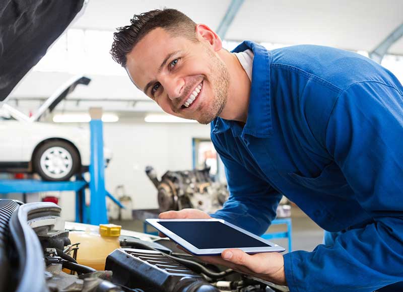 Image a service tech smiling as he works on your car